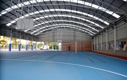 metal structure with a curved roofing in a sport zone in a school with INCO 30.5 by INCOPERFIL